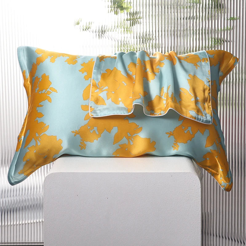 Decorative pillow with yellow floral pattern on a light blue background, placed on a white surface.