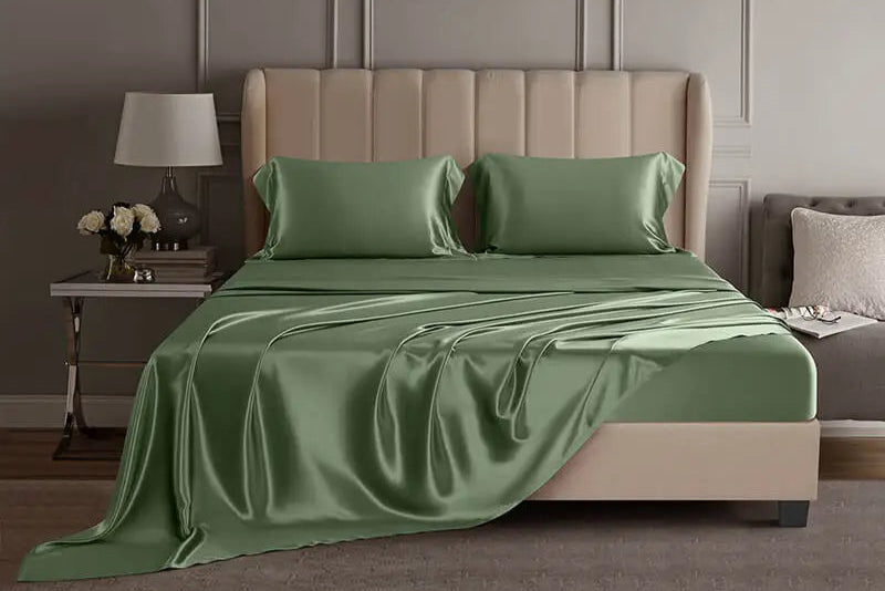 Green mulberry silk sheet set on a bed in a luxury bedroom setting.