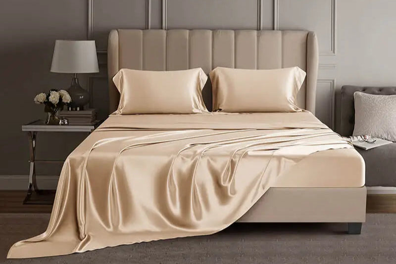 Champagne mulberry silk sheet set on a bed in a luxury bedroom setting.